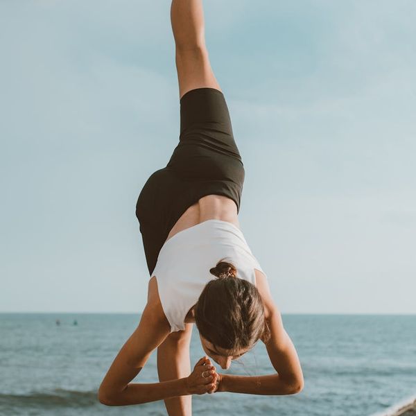 Person stretching gently outdoors, symbolizing flexibility and wellness gained from regular practice.